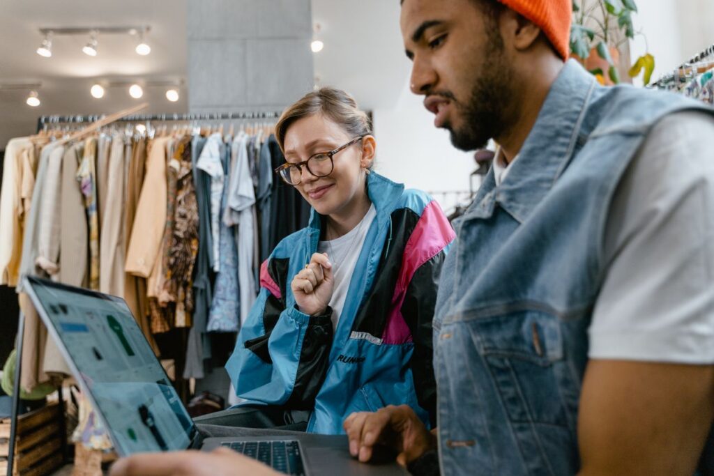 Professionnels comparant un outil de gestion dans une boutique de mode