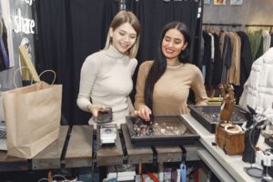 Clientes effectuant un paiement mobile dans une boutique de mode